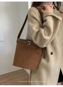 Gros plan sac en daim marron avec boucle vintage sur manteau en tweed beige