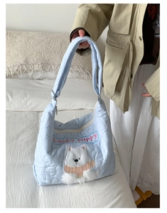 Détail du sac matelassé bleu clair avec coutures en cœur et écusson de chiot mignon