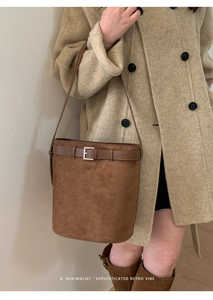 Gros plan du sac seau rétro en daim marron avec bandoulière et boucle métallique