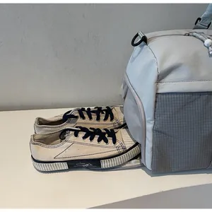 Vue détaillée du sac de voyage gris avec compartiment latéral séparé pour chaussures