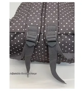 Detail of adjustable gray shoulder straps with black plastic buckles on a star-patterned backpack