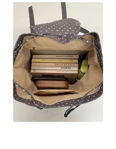 Vertical top view of large capacity grey star backpack interior with books and zipper pocket
