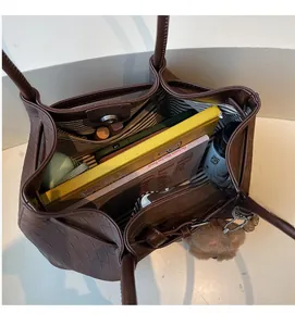 Spacious interior of brown woven tote bag showing striped lining and daily essentials