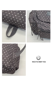 Close-up of reinforced stitching and durable star-patterned canvas on a grey backpack