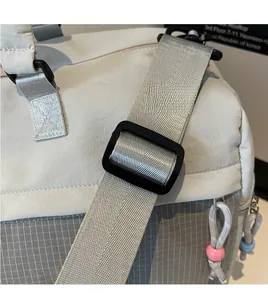 Détail de la bandoulière réglable en nylon gris et de la boucle du sac de voyage