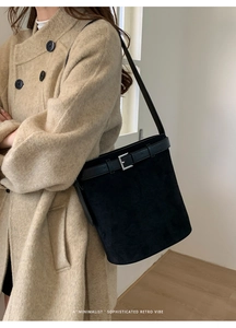 Détail du sac seau en daim noir avec sangle en cuir et boucle en métal argenté