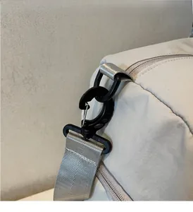 Détail du crochet pivotant noir et de la sangle en nylon gris du sac de voyage