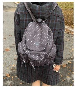 Detail view of large capacity grey star pattern backpack on female model in autumn setting