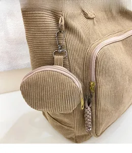 Dettaglio della borsa tote in velluto a coste con ganci in metallo e mini borsellino tondo