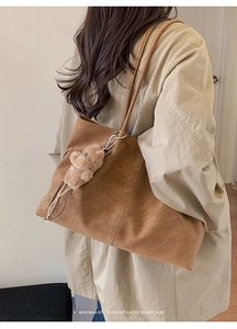 Detail of retro matte brown tote bag with bear charm on beige trench coat outfit