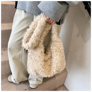 Close-up of beige plush bucket bag showing soft faux fur texture and handle detail