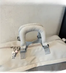 Détail du sac de voyage avec poignées rembourrées et tirettes de fermeture perlées