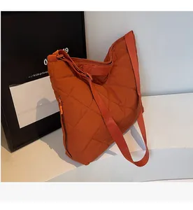Detail view of the quilted burnt orange tote bag with diamond stitching and shoulder strap