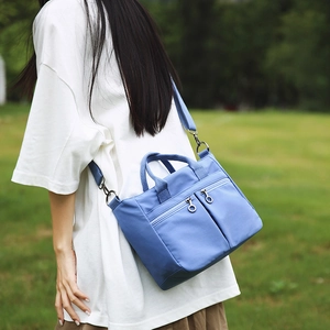 Detail of blue nylon shoulder bag with double zip pockets and adjustable strap