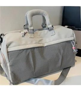 Vue détaillée du sac de voyage gris avec broderie et poignées rembourrées