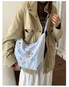Détail du sac hobo matelassé bleu clair avec motifs de cœur et broderie chiot mignon
