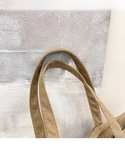 Dettaglio dei comodi spallacci larghi in velluto a coste di una borsa kaki