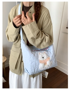 Détail du sac cabas bleu clair matelassé avec écusson chien peluche et texte Lucky puppy