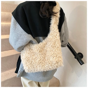 Back view of beige faux fur crossbody bag with wide strap on a female model