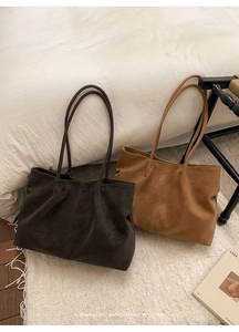 Detailed view of the soft matte leather texture and decorative stitching on tote bags