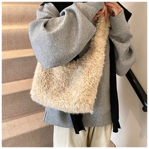 Close-up of fluffy faux shearling shoulder bag showing soft cream white plush texture