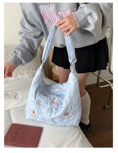 Détail du sac cabas matelassé cœur bleu clair avec broderie chat et desserts