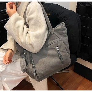 Dettaglio borsa tote in velluto a coste grigio con tasca zip e piccolo portamonete tondo