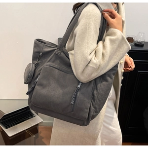 Dettaglio della borsa tote in velluto a coste grigio con tasche e mini portamonete coordinato