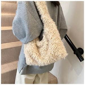 Detail view of the plush beige faux fur shoulder bag with soft curly texture and wide strap