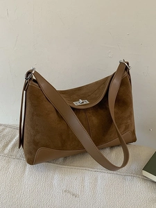 Brown suede underarm shoulder bag with matte finish and silver twist lock detail