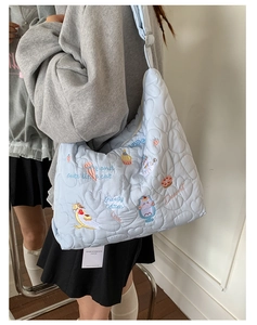 Détail du sac cabas matelassé bleu clair avec broderies de chat et de cupcake