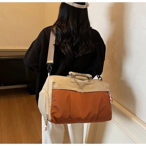 Détail du sac de voyage spacieux montrant le compartiment chaussures et le nylon bicolore