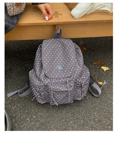 Detail view of large capacity backpack with white stars and KMD Hello woven label