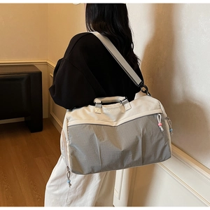 Détail du logo brodé sur un sac de voyage gris texturé pour le sport et le fitness