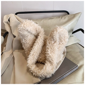 Detail of soft cream faux fur bucket bag texture placed on a white leather chair