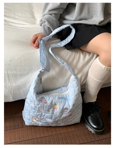 Détail du sac matelassé bleu clair avec broderie chat et motifs de cœurs surpiqués