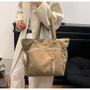 Dettaglio della borsa tote in velluto a coste kaki con tasca a zip e mini borsellino