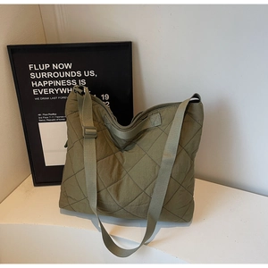 Detailed close-up of olive green quilted tote bag showing large diamond stitching pattern