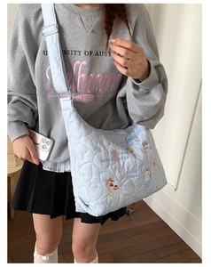 Gros plan du sac cabas bleu clair matelassé à cœurs avec broderie de chat mignon