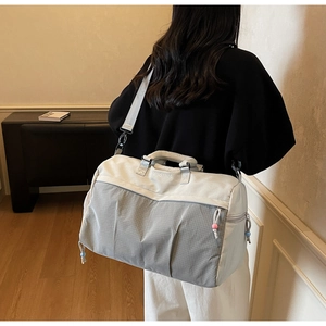 Vue détaillée du sac de voyage à motif écossais beige et gris avec perles de fermeture