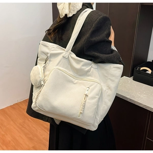 Dettaglio della borsa tote in velluto a coste bianco con tasca laterale e mini borsellino