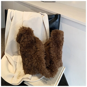 Detailed close-up of brown plush faux fur bucket bag resting on a book background
