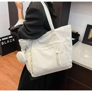 Dettaglio borsa tote in velluto a coste bianco crema con tasca con zip e mini portamonete
