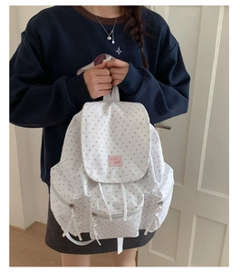 Detail of white canvas backpack with pink star pattern and Kid Hello woven patch