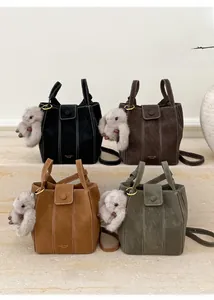 Detail of four retro bucket bags with plush bunny charms and gold logo on faux suede