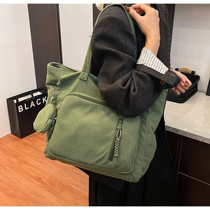 Dettaglio della borsa tote in velluto a coste verde con tasca zip e mini portamonete