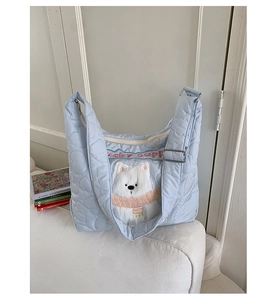 Détail du sac cabas bleu clair matelassé en cœur avec écusson pelucheux de chiot chanceux
