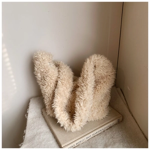 Detail of soft cream faux fur bucket bag texture with side zipper and wavy plush design