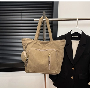 Dettaglio borsa tote in velluto a coste kaki con tasca frontale e mini borsellino