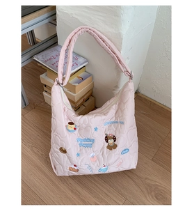 Détail du sac à bandoulière rose matelassé avec broderies de chiots et patchs mignons
